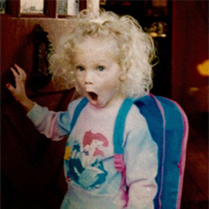 Young Taylor Swift with curly blonde hair wearing The Little Mermaid shirt